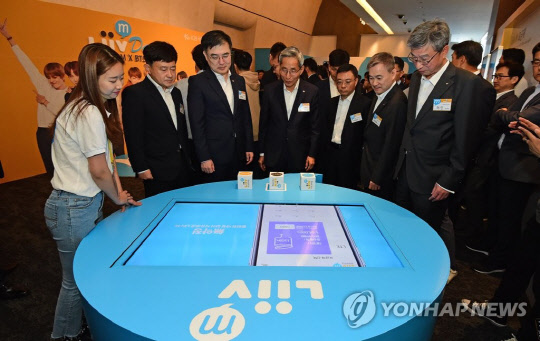 지난달 28일 서울 중구 반얀트리 클럽 앤 스파 서울에서 열린 KB국민은행 혁신금융서비스 '리브모바일'(Liiv M) 론칭 행사에서 윤종규 KB금융지주 회장을 비롯한 내빈들이 리브모바일을 체험하고 있다. 왼쪽 두 번째부터 최성호 방송통신위원회 이용자정책국장, 손병두 금융위원회 부위원장, 윤 회장, 이태희 과학기술정보통신부 통신정책국장, 하현회 LG유플러스 부회장, 허인 KB국민은행장.